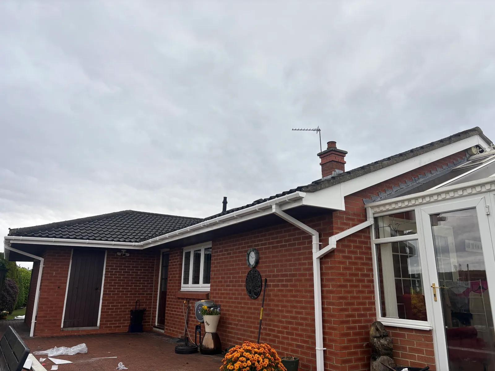Another angle of the bungalow roofline in Binchester Moor, showing white guttering and a white downpipe beside the conservatory.