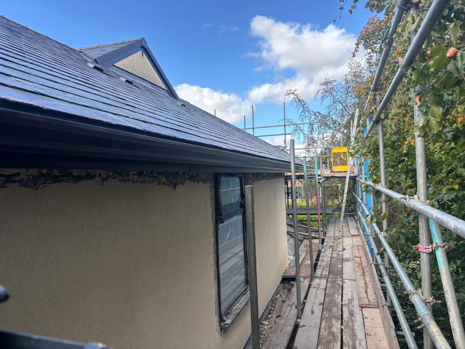 Installed seamless guttering along the eaves, with scaffolding still in place.